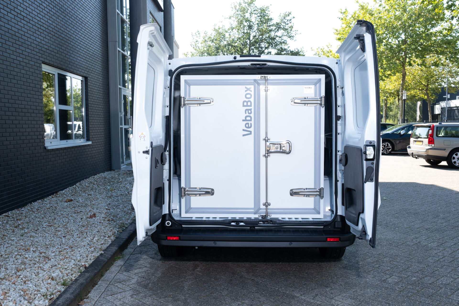 Rückansicht eines Nutzfahrzeugs mit offenen Türen, in dem eine VebaBox mobile Kühleinheit passgenau im Laderaum untergebracht ist.